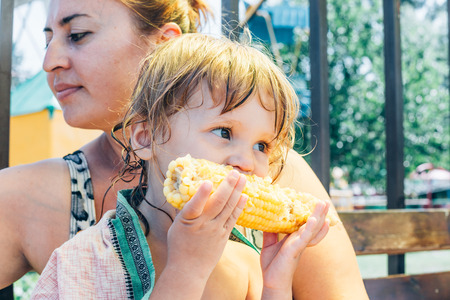 Little girl eat corn, close-up photos.の写真素材