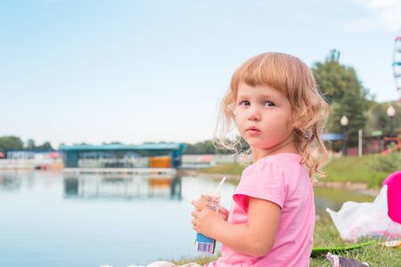 Happy little girl playing outdoors in the day.の写真素材