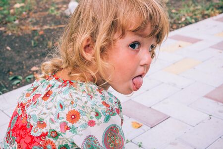 Curly blond child playing outdoors in summer. Healthy lifestyle of child development. The concept of...