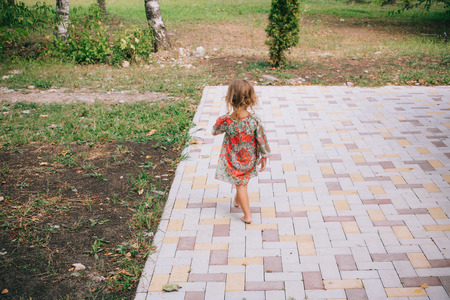 Curly blond child playing outdoors in summer. Healthy lifestyle of child development. The concept of well-being, prosperity.の写真素材