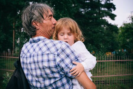 Family girl in the arms of his father outdoors. The concept of a happy family.