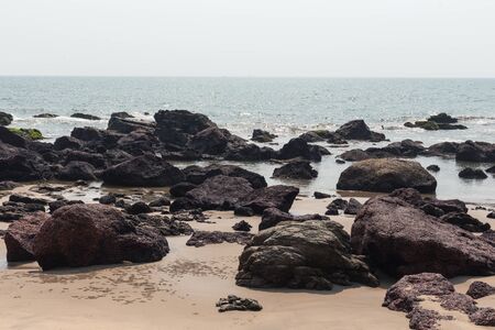 Turquise sea with a tropical beach. The coastline of the ocean, rocks and sand. Sea line with Arambol on the beach of Kerem, Goa, India. Active holidays in paradise resorts, concept travel lifestyle.の写真素材