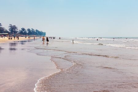Tropical sandy beach of Arambol. View of the sea with clouds on the coastline. Paradise resort Goa...