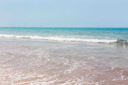 View from a tropical sandy beach on sea turquoise with clear water in clear weather. Paradise view of the ocean with waves and blue sky. South Goa, India. The concept of an exotic vacation, travel, lifestyle, adventure.の写真素材