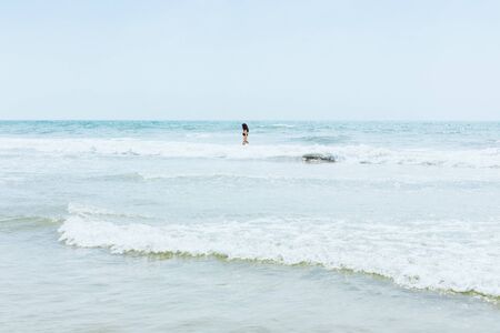 Tropical beach, the girl enjoys in a turquoise sea with clear water. Paradise view of the ocean with...