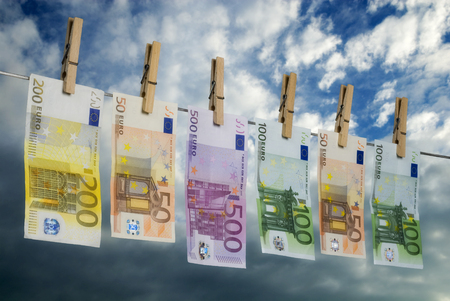 Euro bills hanging on a washing line, symbolizing money laundering の写真素材