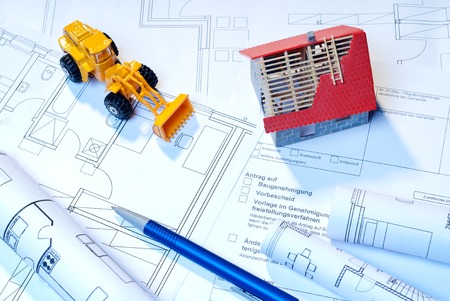 Construction plans, architectural model and toy excavator as symbols for Construction の写真素材