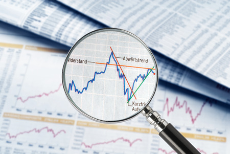 Magnifier over newspaper with stock prices and exchange rate tables の写真素材