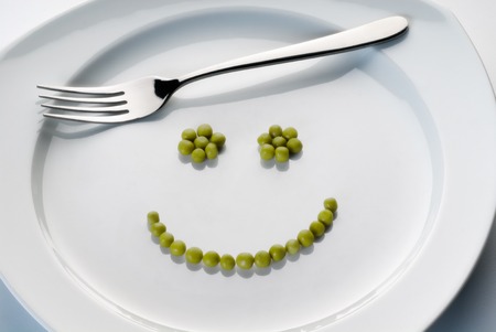 Plate with peas forming a smiley の写真素材