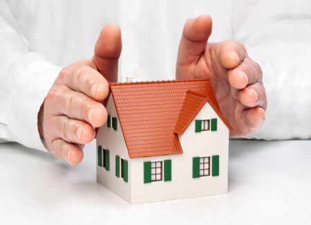 Hands protectively enclose an architectural modelの写真素材