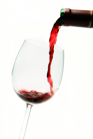 Red wine being poured from a bottle into a glassの写真素材