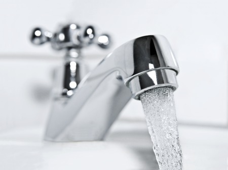 drinking water flows from a chrome water tap の写真素材