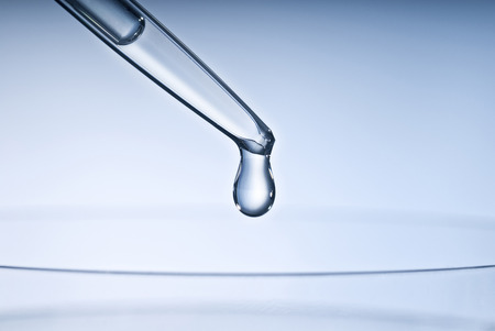 Pipette with drop and petri dish の写真素材