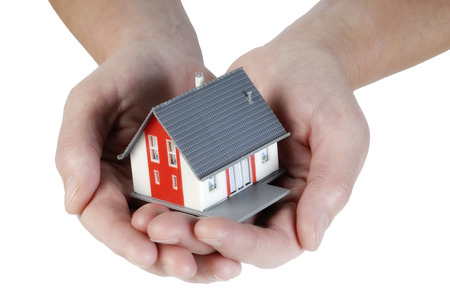 Hands holding a house carefullyの写真素材