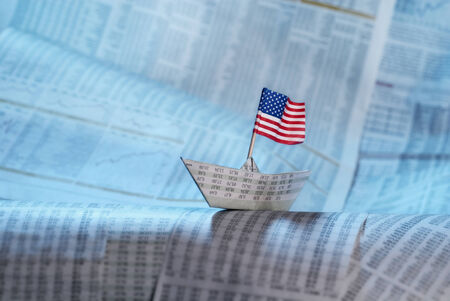 Paper boat with US flag shipping on financial news.の写真素材