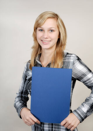 Young pretty woman in business outfit with blue folderの写真素材