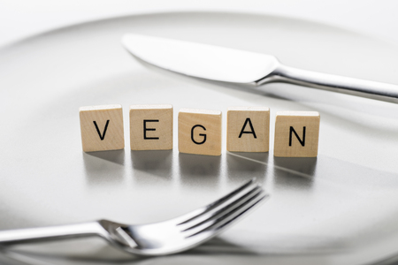 Plate with cutlery and the word \"vegan\" for vegan dietの写真素材