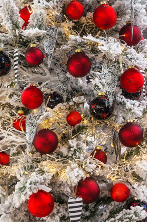 Many red Christmas baubles on a Christmas tree with white snow.の写真素材