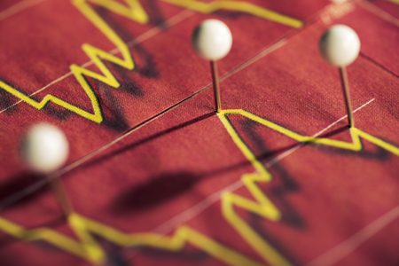Pushpins mark stock price on red background.の写真素材