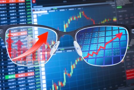 Glasses shows rising courses with financial data in the backgroundの写真素材