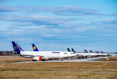 Lufthansa aircraft (Airbus A330 and 340) are parked on the north-west runway of Frankfurt Airport as a result of the corona pandemic. Frankfurt, Hessen / Germany - March 30 2020のeditorial素材
