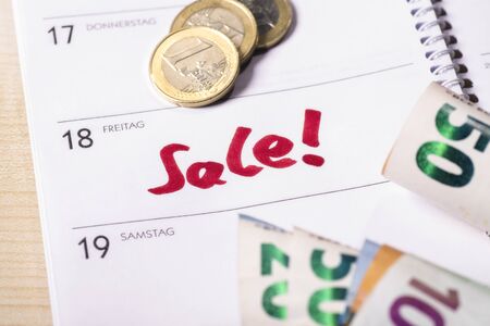 Date for sale in the calendar on which are coins and bank notes.