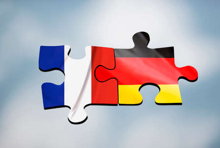 Two puzzle pieces with flags of France and Germany on abstract blue backgroundの写真素材