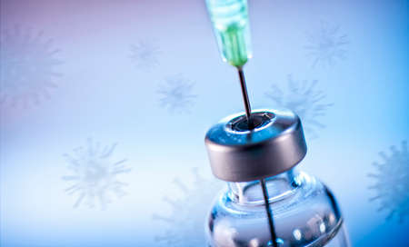 Vials with vaccine against corona with viruses in the backgroundの写真素材