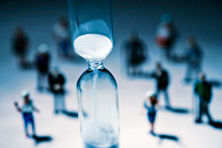 Hourglass with a group of people in the backgroundの写真素材