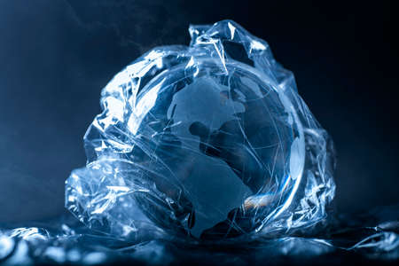 Symbol photo World in plastic. Globe wrapped with plastic film.の写真素材
