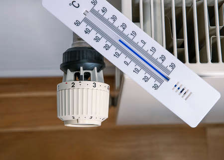 Thermometer lies on a radiator to measure the room temperature.