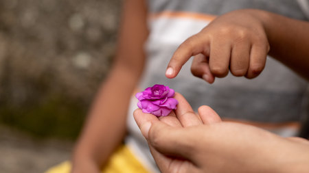 Women/parent wants kid touch her flower with his fingerの写真素材