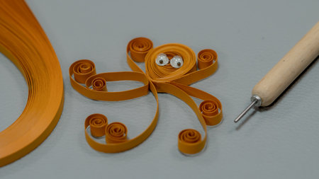 paper quilling crafts, paper octopus with a needle on a gray backgroundの写真素材