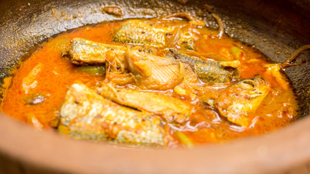 Fish stew in a clay pot on a wooden table close-upの写真素材