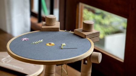 Wooden stand hoop with flower decoration at  home, close-up. Embroidery Craftsmanship.