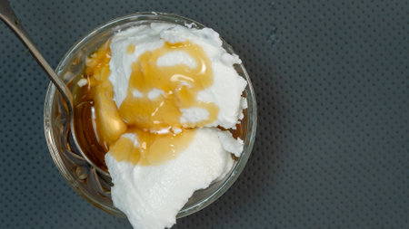 Curd in a glass bowl with kithul treacle and spoon on the table