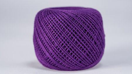 Ball of purple yarn on a white background, closeup of photo
