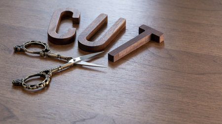 CUT, word of wooden letters and scissors on a wooden backgroundの写真素材