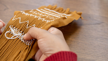 The Art of Smocking: Woman's Hand Creates Delicate Gathers on Pleated Cotton for Dressmaking.の写真素材