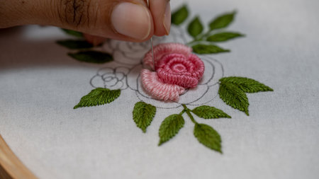 Floral Needlework: Hand Stitching a Rose Flower with Pink Thread on Fabricの写真素材