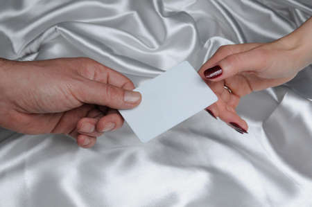 Handing over blank card, male and female hand 