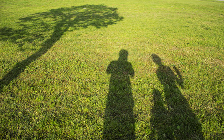 silhouette family with shadows in grass fieldの写真素材