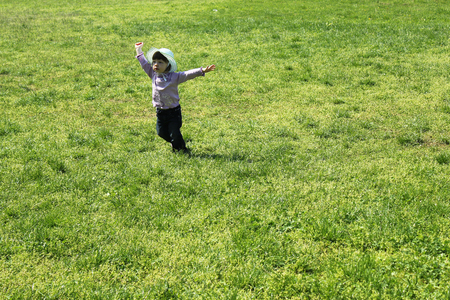 cute small girl running in  grass park の写真素材
