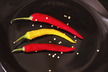 chilli and seed on black plateの写真素材
