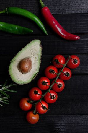 Mexican nachos with sauces tomato ketchup, cheese and guacamole in wooden bowl on dark background, top view, copy space. Delicious salty corn chips triangular nachos snack for partyの写真素材