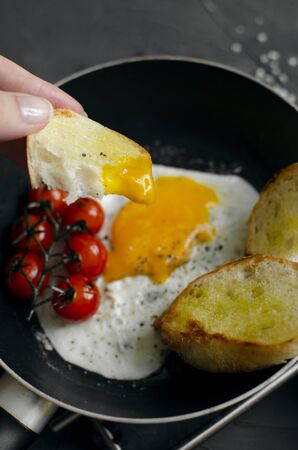 Fried egg in a frying pan with breadの写真素材