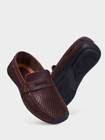 Men's brown leather summer loafers with perforation and black sole. Isolated on a white background.の写真素材