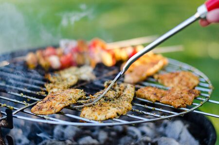 Grilled meat and vegetables with forkの写真素材