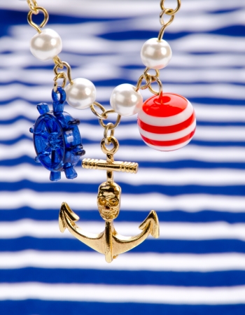 Gold anchor with blue-white striped backgroundの写真素材