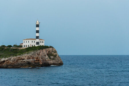 Lighthouse with rock at sunriseの写真素材